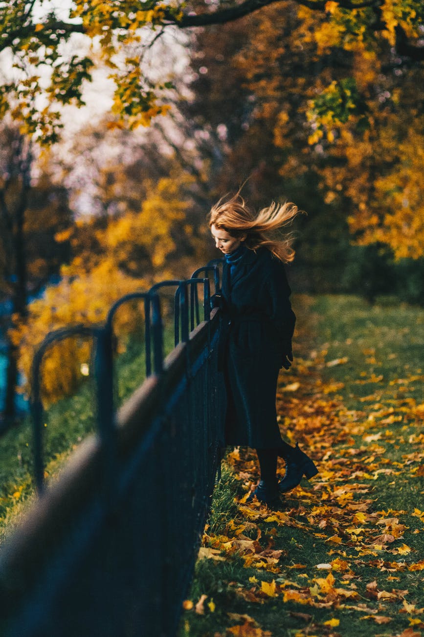 woman wearing black coat near railings